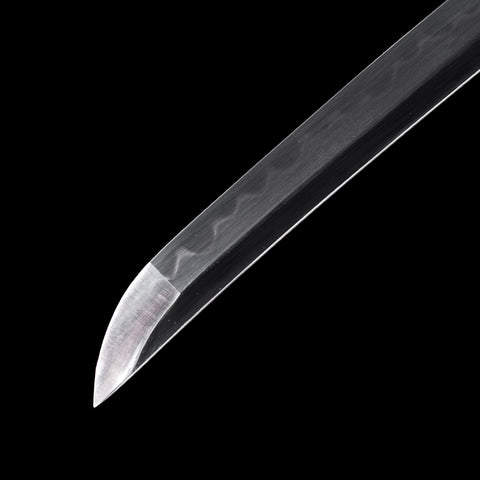 A dramatic close-up of the Bloodbane blade reflecting light off its polished surface and dark finish.

