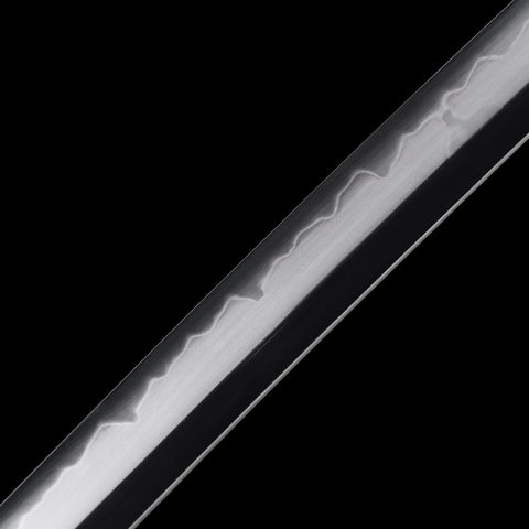 Katana’s high-carbon steel blade reflecting light, emphasizing its polished finish

